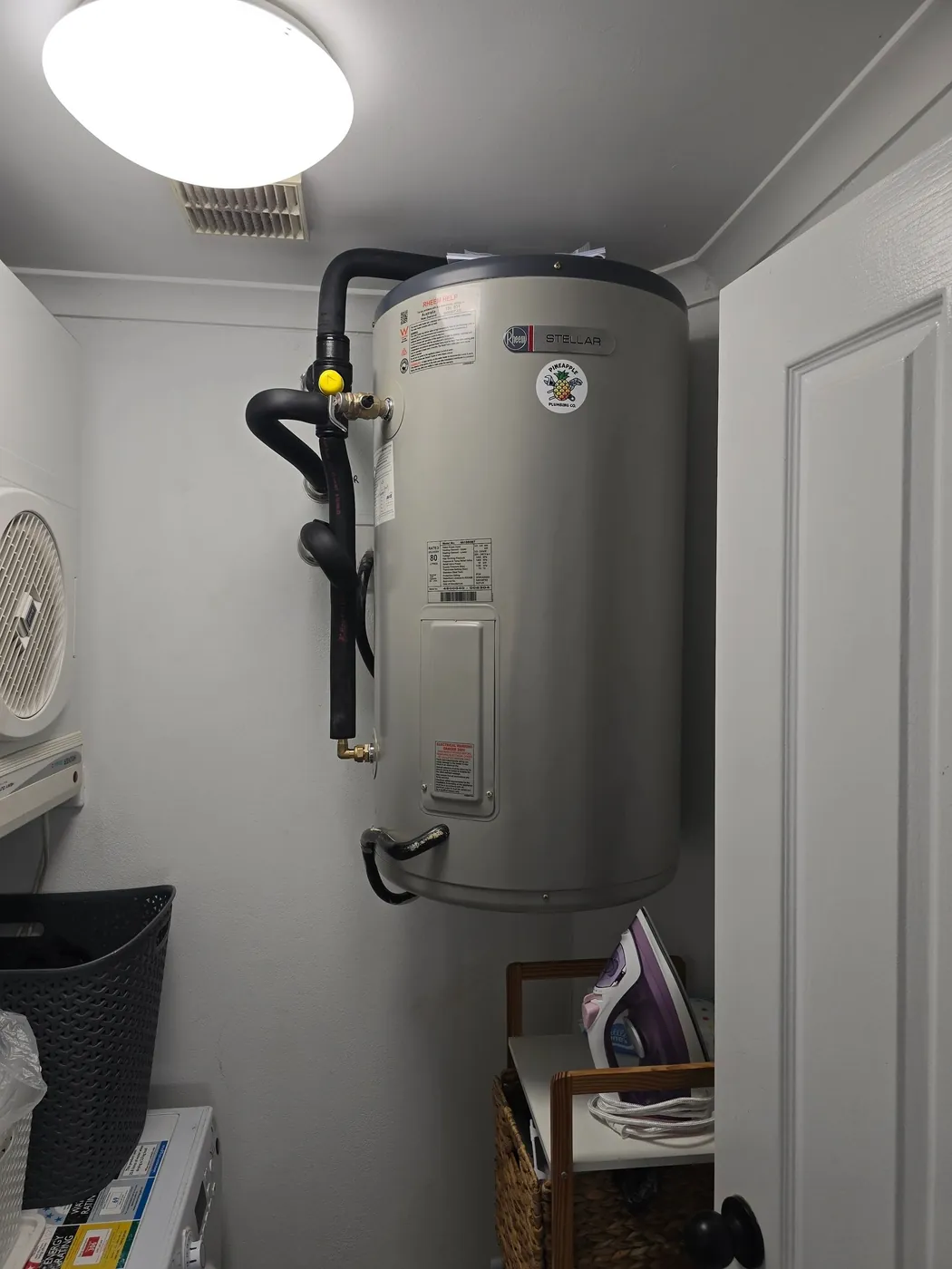 Electric hot water cylinder installed in a laundry cupboard