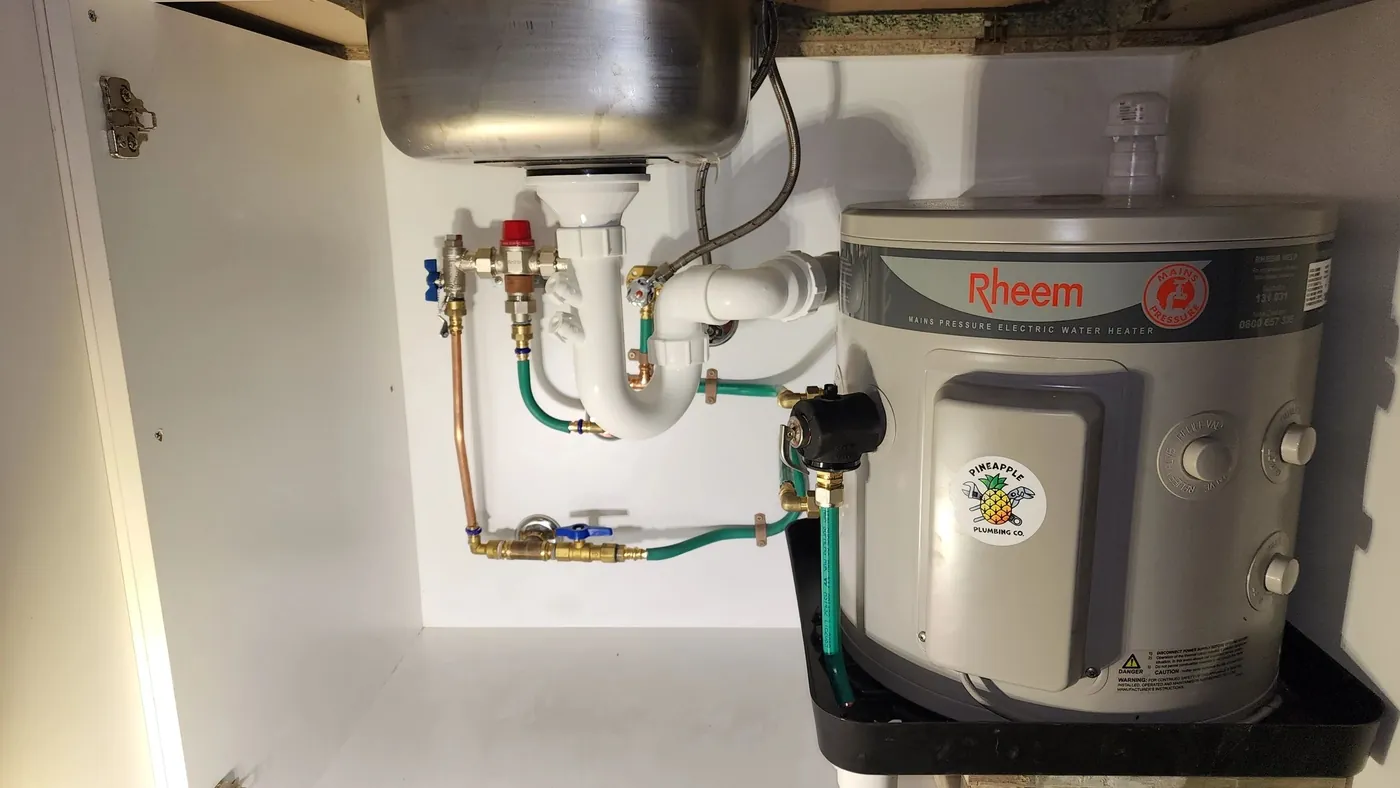 Rheem hot water unit installed under a sink with new valves and pipework